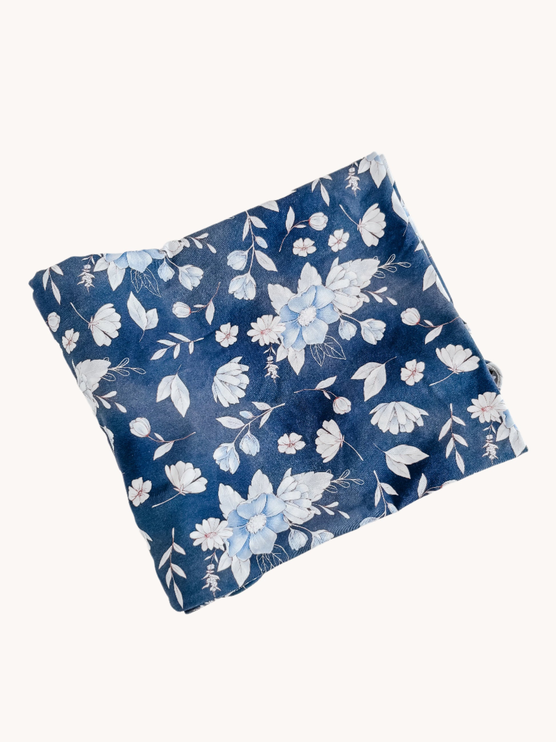 Floral-patterned blue pillow on a white background