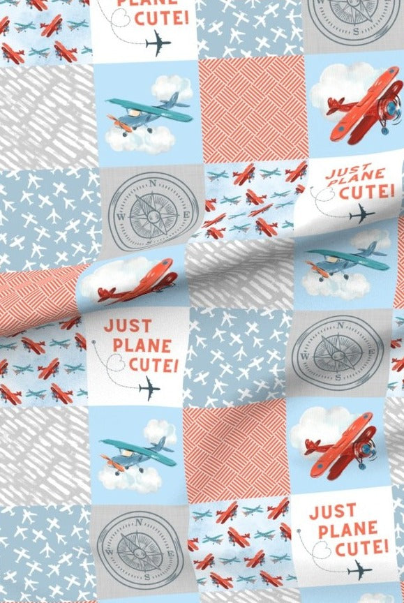 Just Plane Cute premium minky fabric — red biplanes, clouds and compasses in patchwork squares of sky blue and coral