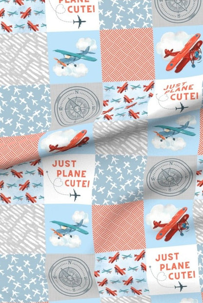 Just Plane Cute premium minky fabric — red biplanes, clouds and compasses in patchwork squares of sky blue and coral