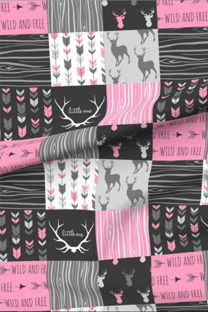 Little Hunter Hot Pink minky fabric — patchwork squares of stag silhouettes, deer, arrows and wood grain in charcoal, bright pink and grey, with antlers around the words little one and bands reading wild and free